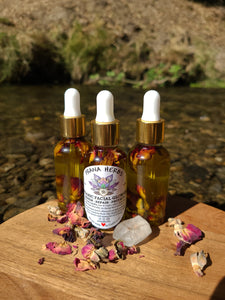 New organic facial glow oil in clear glass bottle with rosebuds and rose petals in a creek with crystals